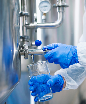 Mãos com luvas coletando amostra de água