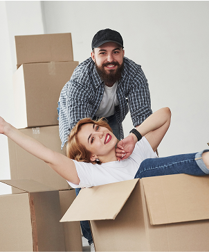 Casal sorrindo com caixa de mudanças