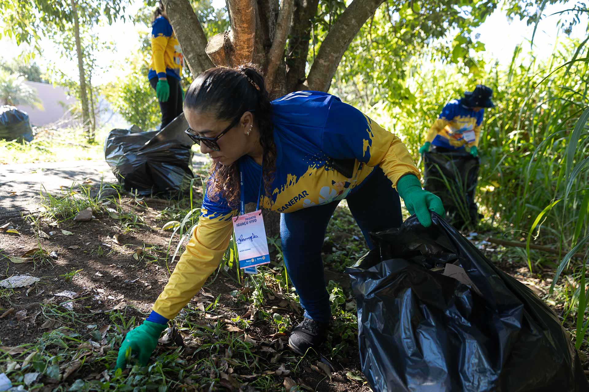 Voluntários da Sanepar limpando as margens do Rio Belém