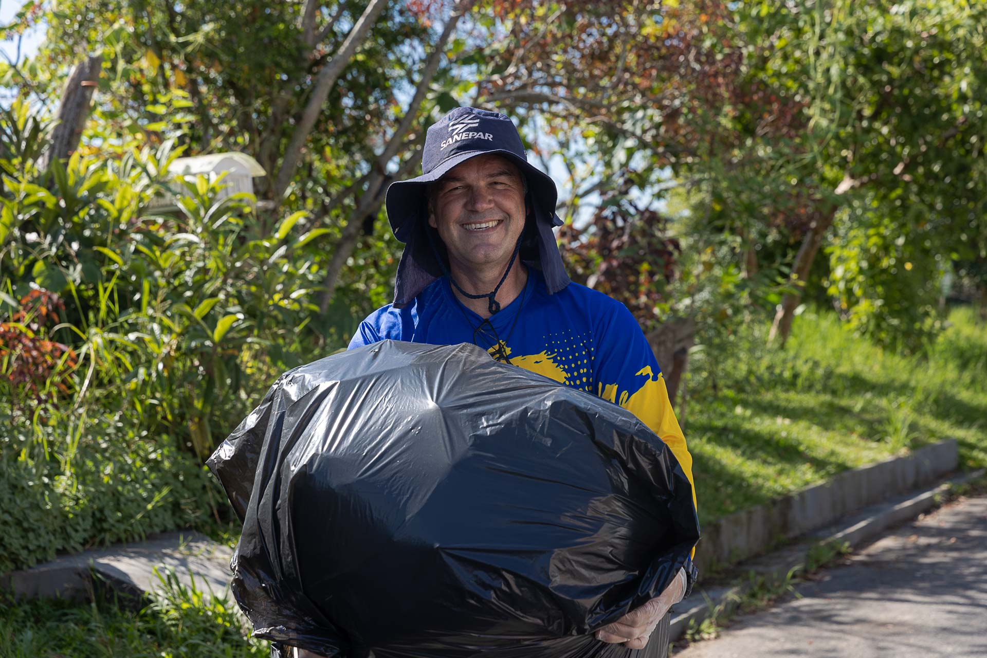 Voluntários da Sanepar limpando as margens do Rio Belém