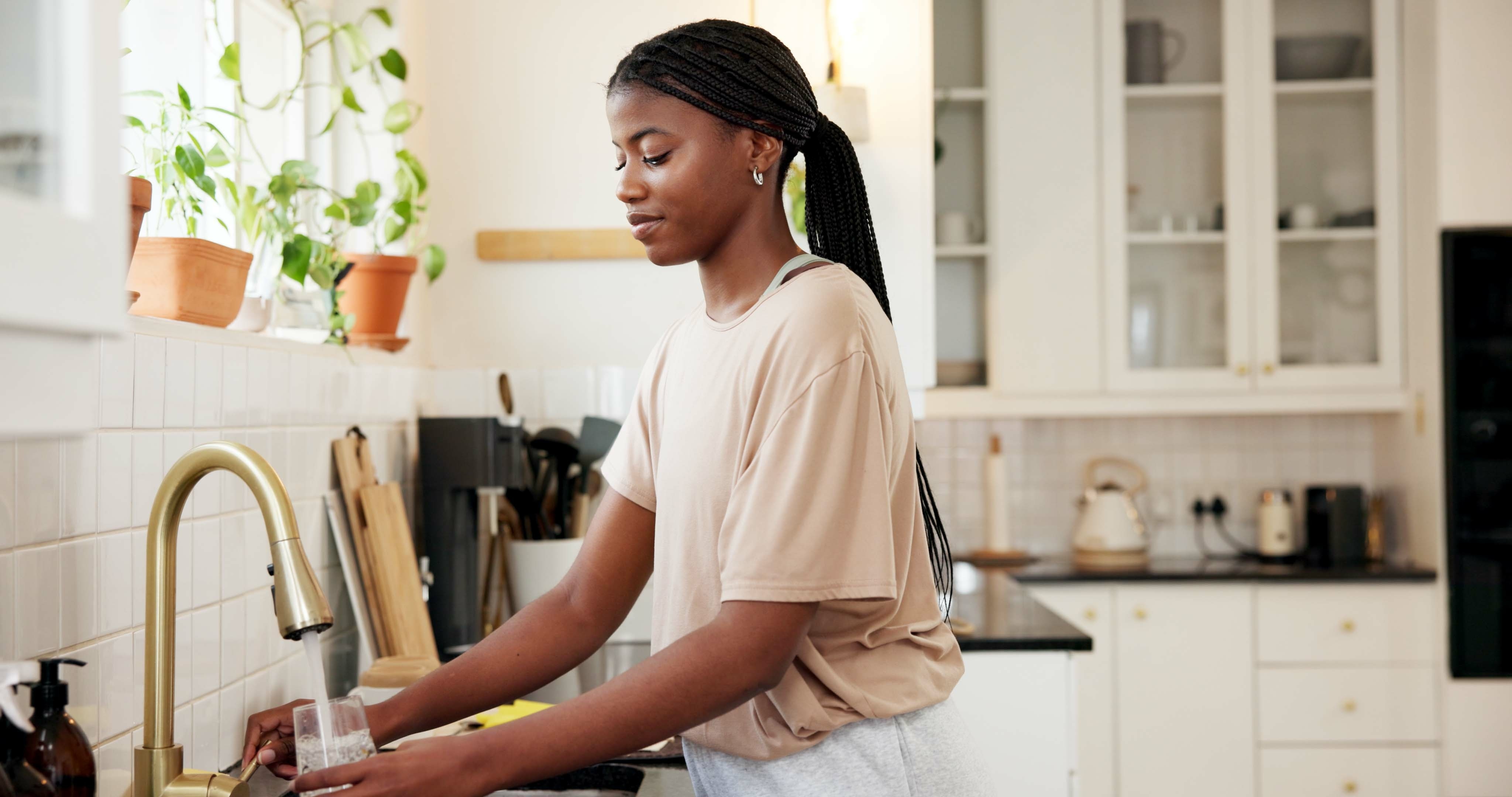 Mulher bebendo água da torneira