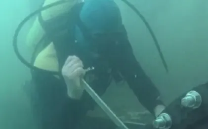 Mergulhador usando ferramenta para apertar parafuso embaixo da água