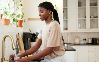 Mulher bebendo água da torneira