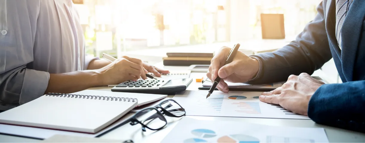 Imagem duas pessoas analisando relatórios. 