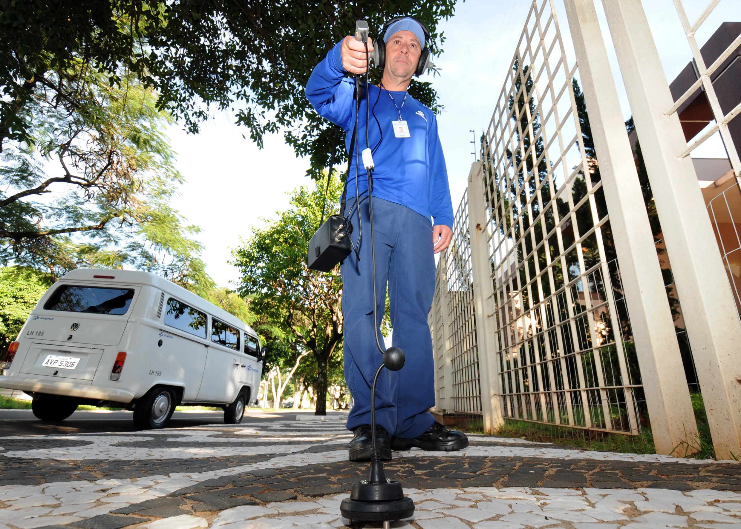 Homem com haste na mão de aparelho de escuta do solo 